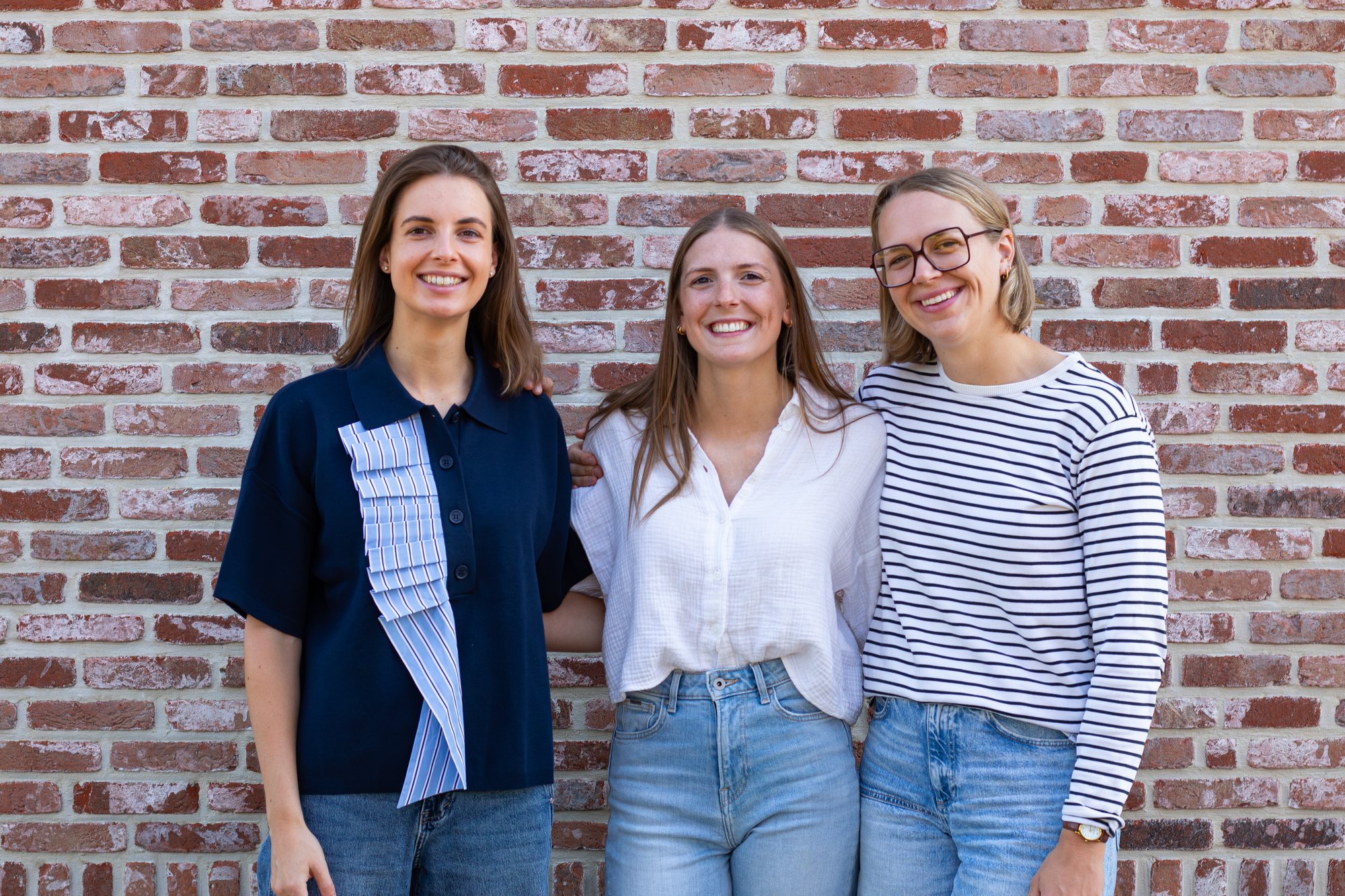 Het team van 't Parkoer voor een bakstenen muur.